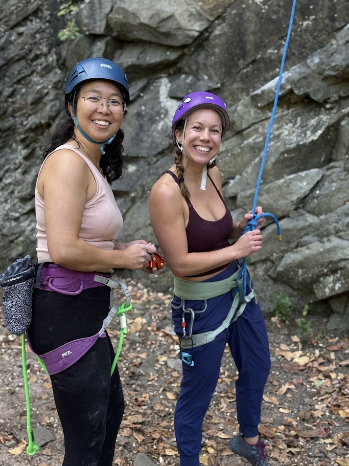 Two climbers gearing up at an outdoor crag